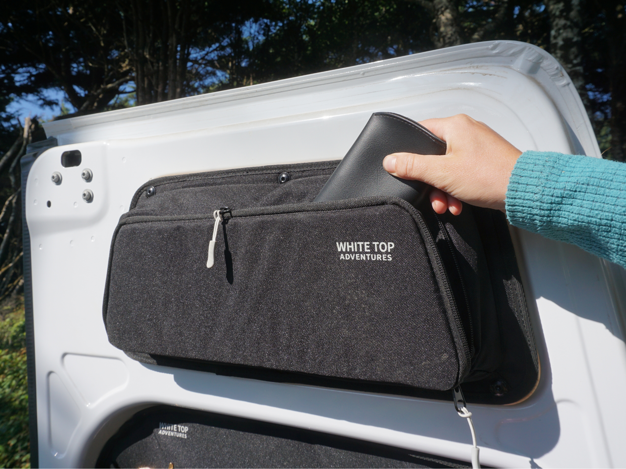 Black upper rear door storage panel with zippered pocket, angled install view (pair)