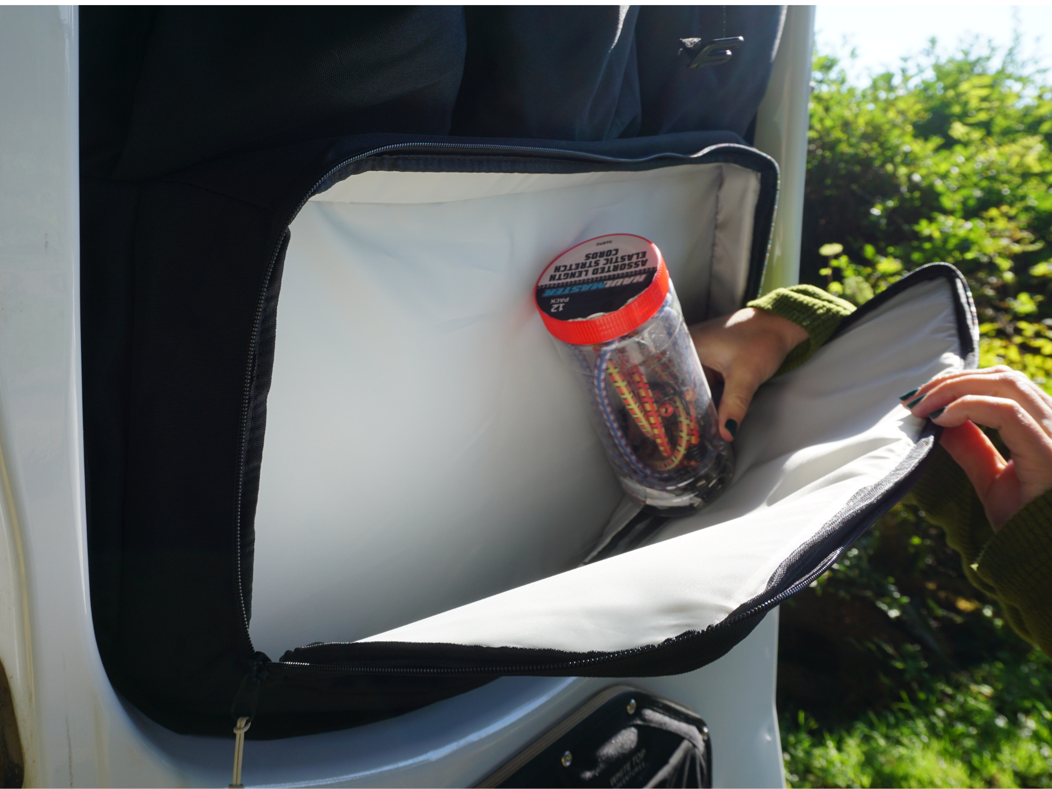 Black storage panel pocket holding bottled drinks and other small items