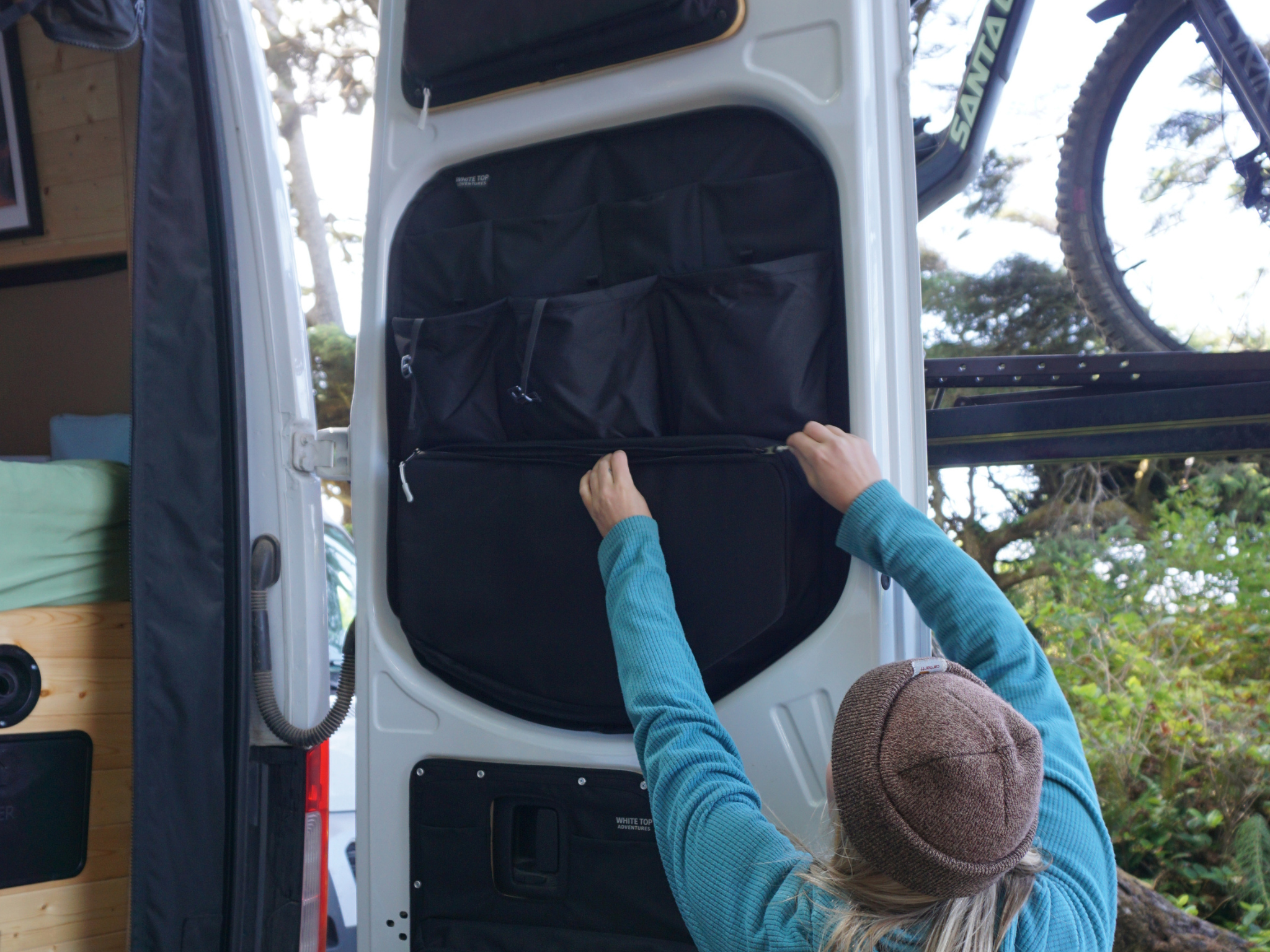 Black door-mounted storage panel with pockets on an open Mercedes Sprinter rear door