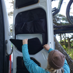Black rear door storage panel with large pocket and divider sections, door open