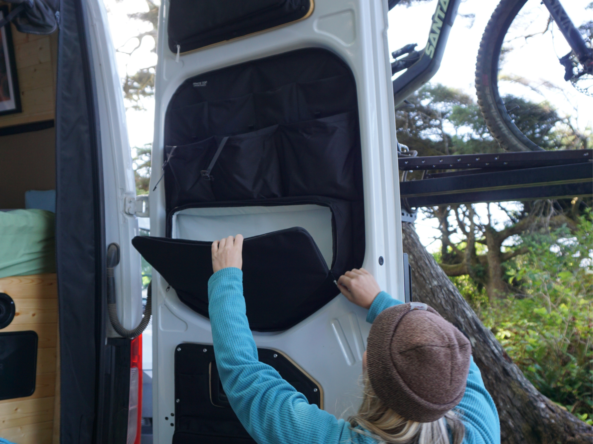 Black rear door storage panel with large pocket and divider sections, door open
