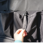 Black storage panel pockets with zipper pull tab and tie strap detail