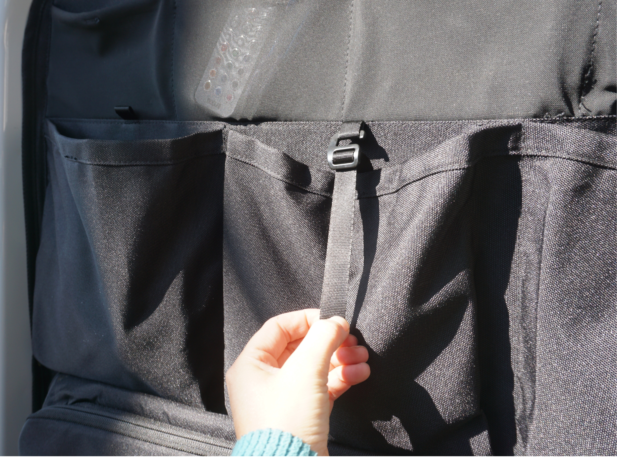 Black storage panel pockets with zipper pull tab and tie strap detail