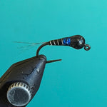 Black and blue fishing lure with feathered tail and curved hook