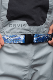 Wading belt with black buckle and blue patterned strap on light gray wader