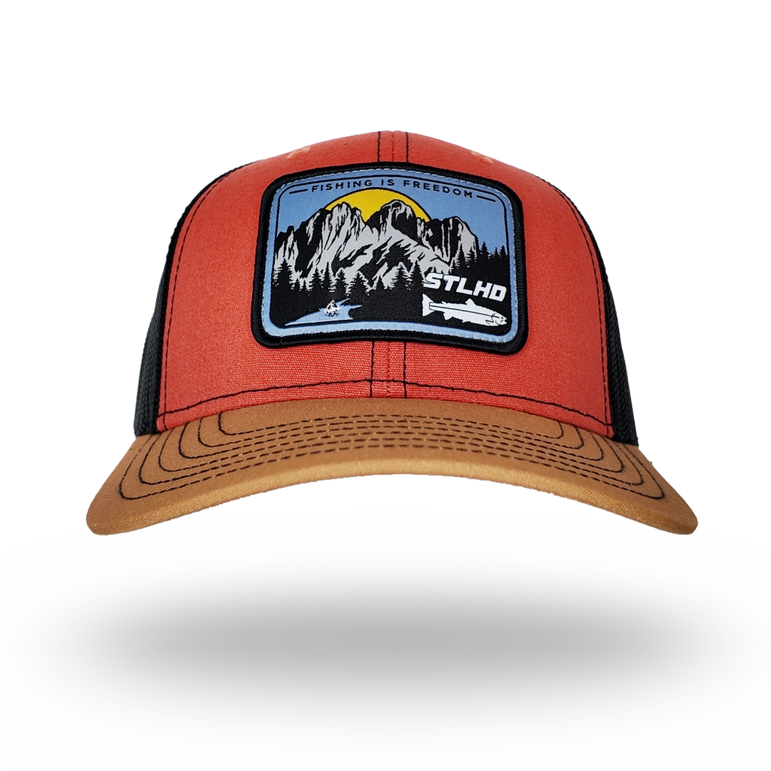 Orange-red trucker cap with black mesh and landscape front patch