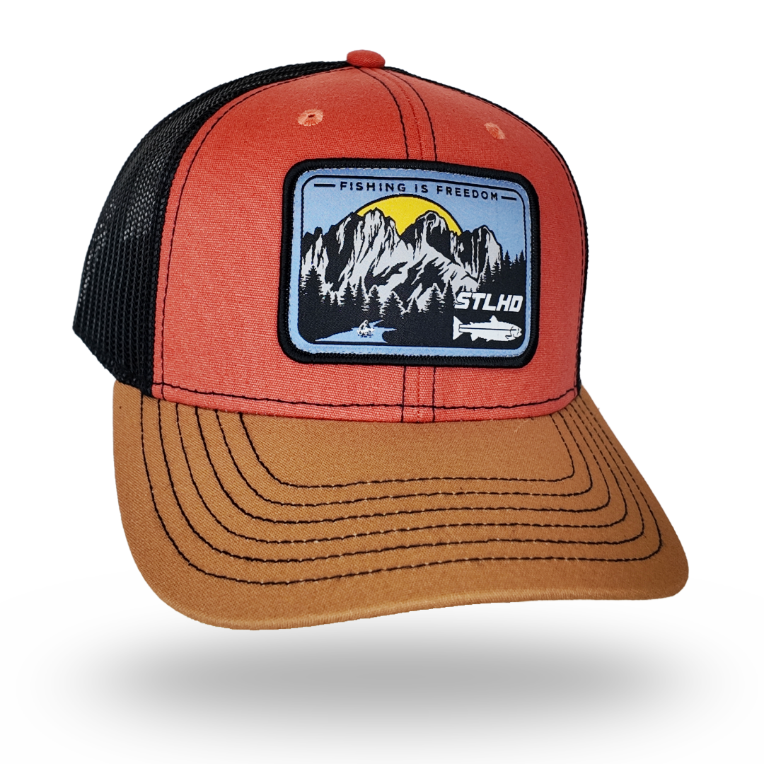 Red and tan trucker cap with black mesh sides and front logo patch
