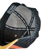 Black trucker cap back panel with woven branding tag and tan brim