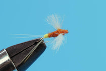 Orange and tan dry fly with white trailing fibers on black hook