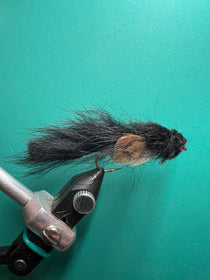 Black sculpin-style fishing lure with fuzzy body and bare hook