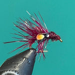 Feather fly fishing lure with black body and purple-pink marabou tail