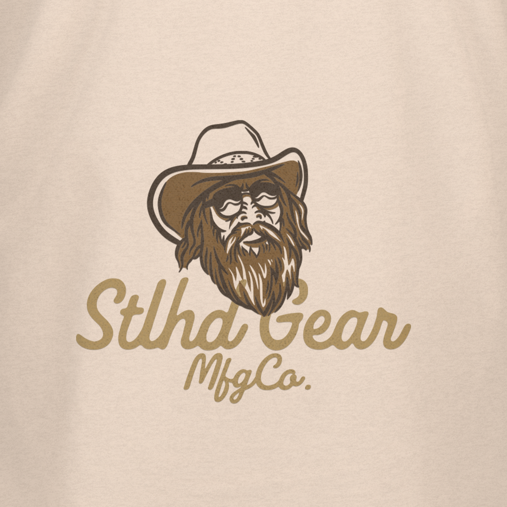 Light tan T-shirt with Stlhd Gear Mfg Co. cowboy face logo on chest.