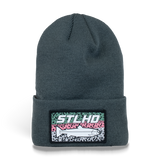 Dark teal knit beanie with ribbed cuff and rectangular STLHD patch logo