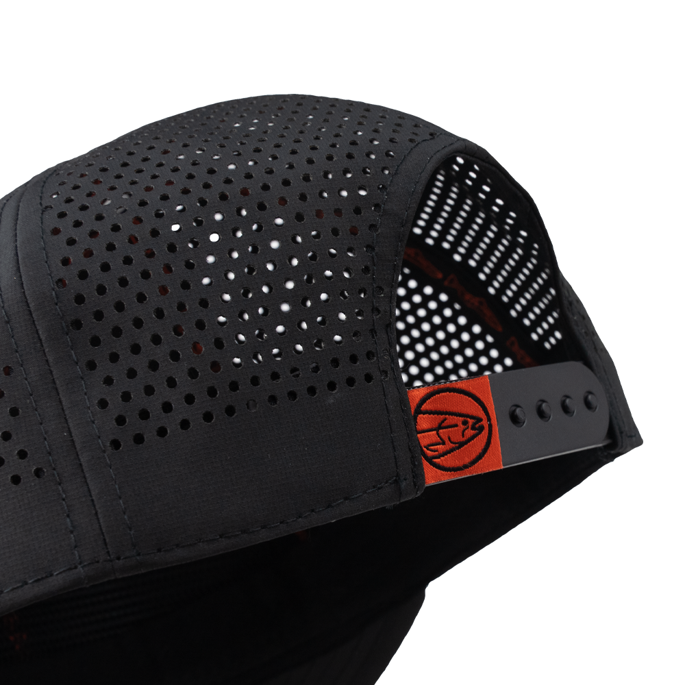 Black trucker cap side with perforated panels and orange adjustable strap