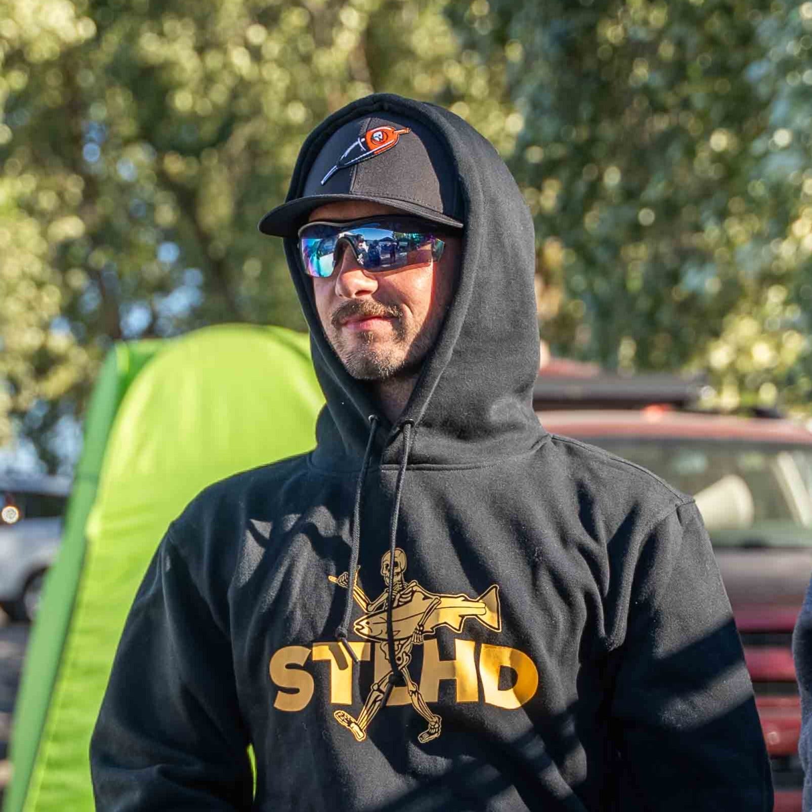 Black performance trucker cap with orange STLHD logo patch