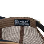 Tan trucker cap interior mesh with STLD GEAR label and stitched seam detail