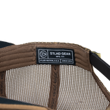 Tan trucker cap interior mesh with STLD GEAR label and stitched seam detail