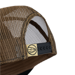 Tan mesh back trucker cap with black adjustable strap and side eyelets