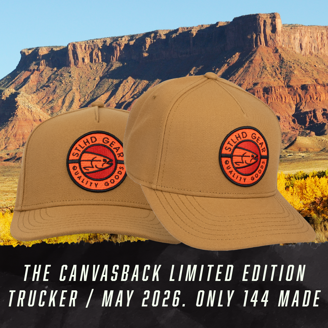 Two tan canvas caps with red-edged STLHD Gear patch, curved brim and top button