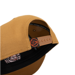 Tan cap with open side showing interior label and orange adjustable strap