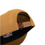 Tan cap with open side showing interior label and orange adjustable strap