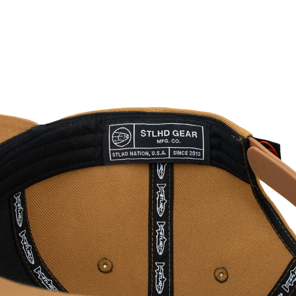 Black-lined cap interior with STLHD Gear MFG Co label and adjustable strap