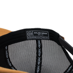 Black mesh trucker cap interior with white brand label and logo pattern
