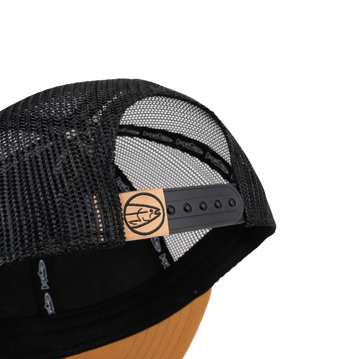Black mesh trucker cap with snapback strap and tan leather logo patch