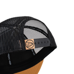 Black mesh trucker cap with snapback strap and tan leather logo patch
