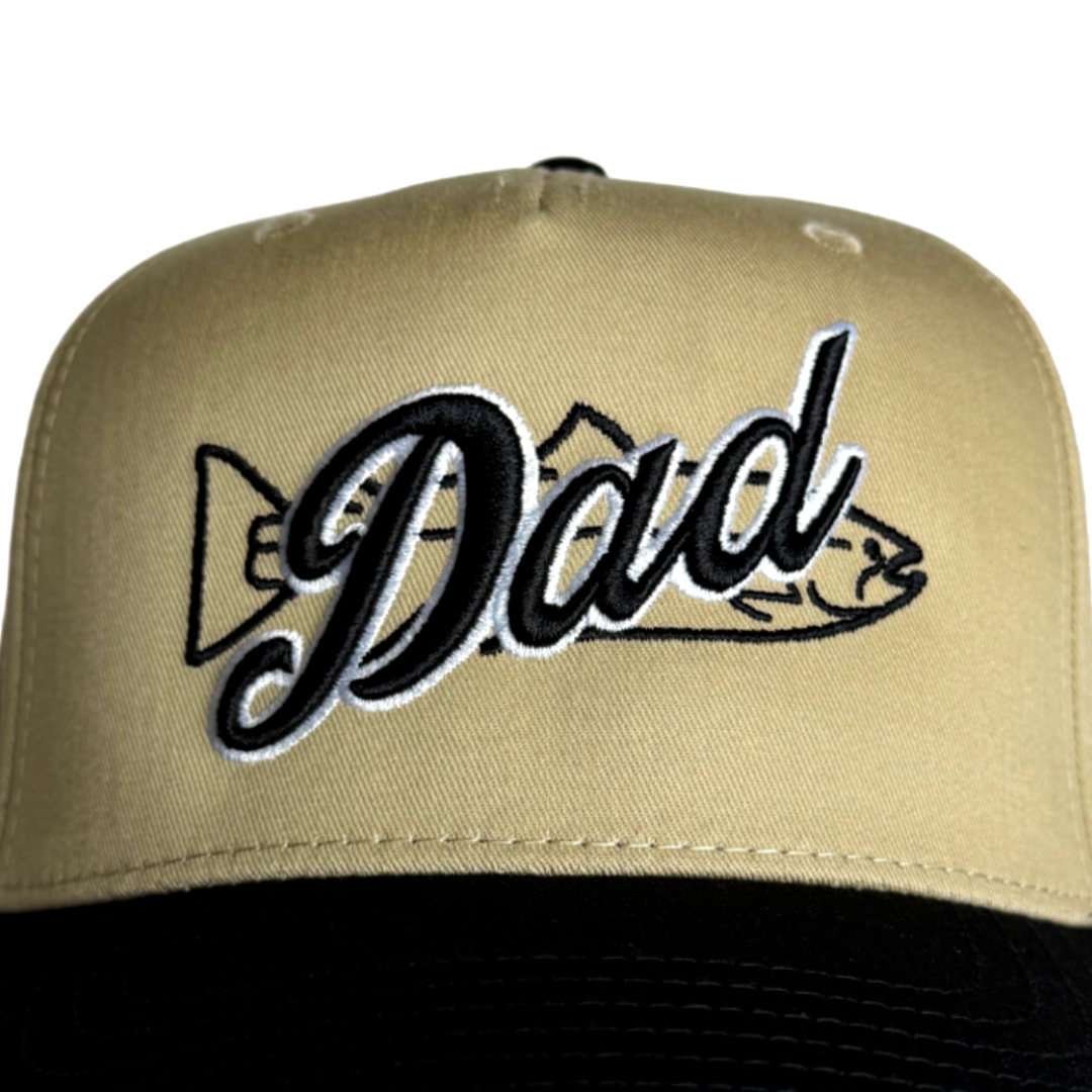 Close-up khaki dad hat with embroidered 'Dad' lettering and bow graphic
