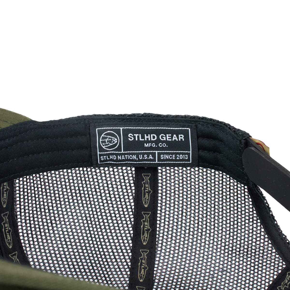 Olive green trucker cap interior with STLHD GEAR label and mesh lining