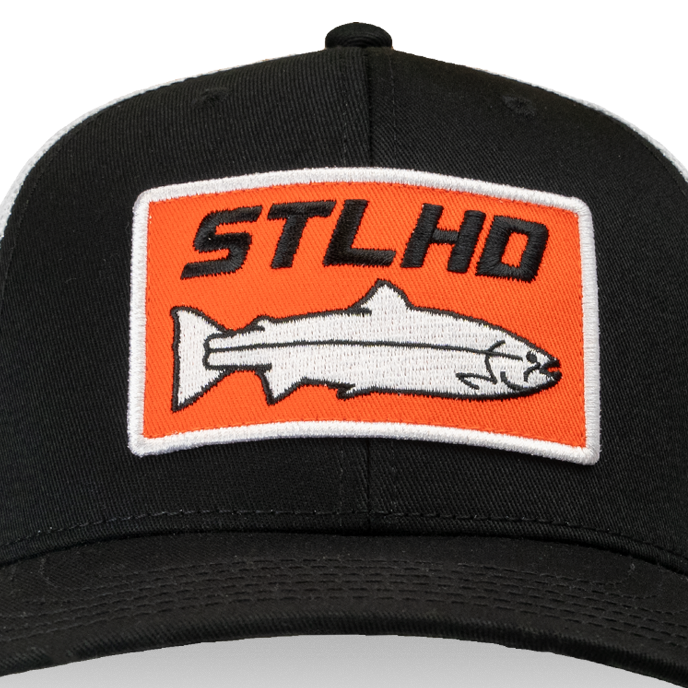 Black flex-fit cap close-up of orange embroidered logo patch and fish graphic