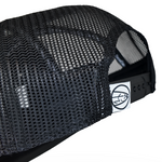 Black trucker cap with textured mesh side panels and black adjustable strap