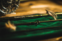 Fishing rod with cork handle, black reel seat, and guide ring on green fabric