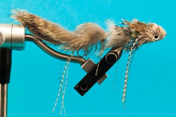 Natural brown feather fly lure on metal hook with black mounting bar