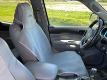 Gray neoprene seat cover set with white piping, fitted over front seats and headrests