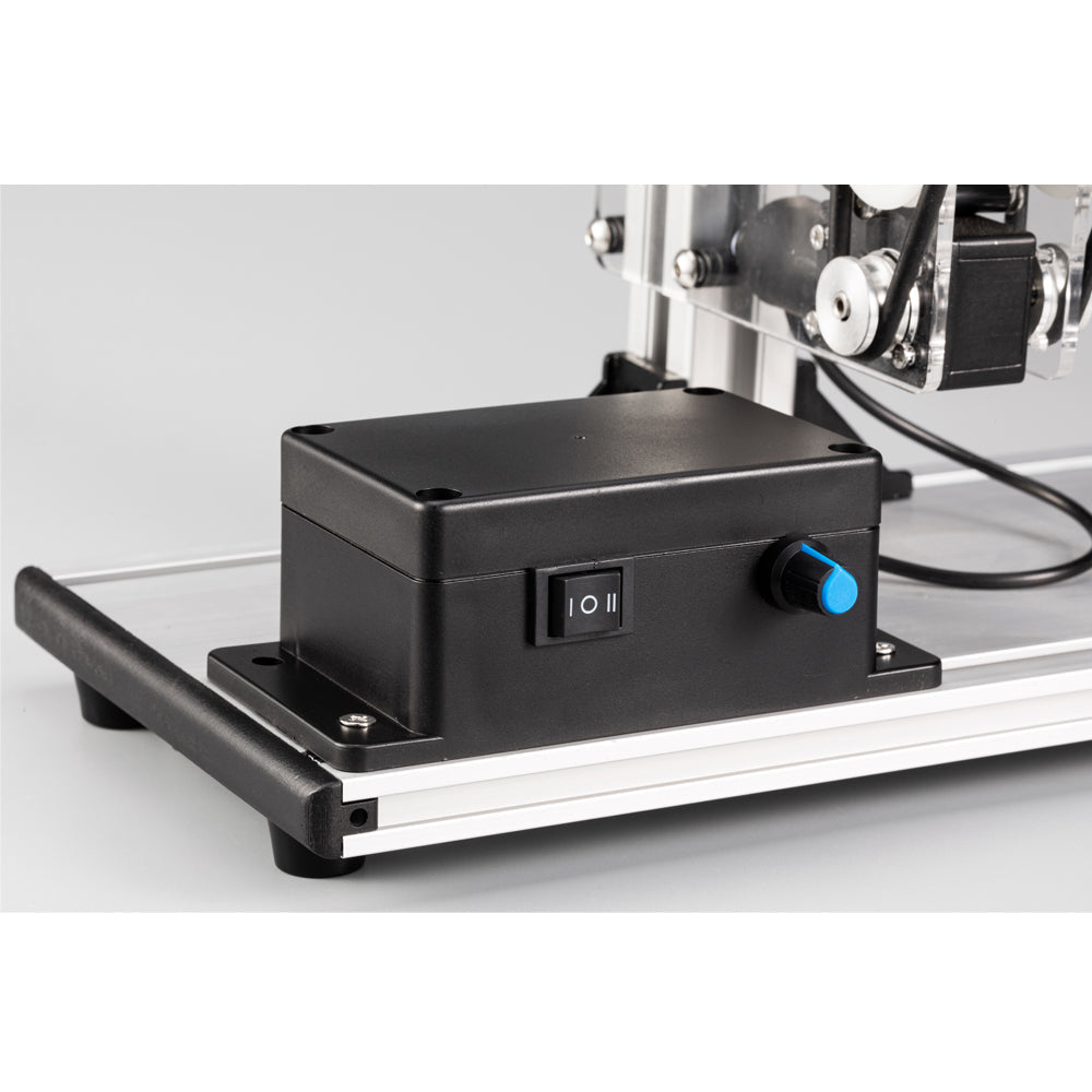 Black control box with on/off switch and blue button on machine base