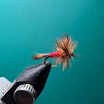 Wulff fly fishing lure with pink-and-tan fibers on a black hook