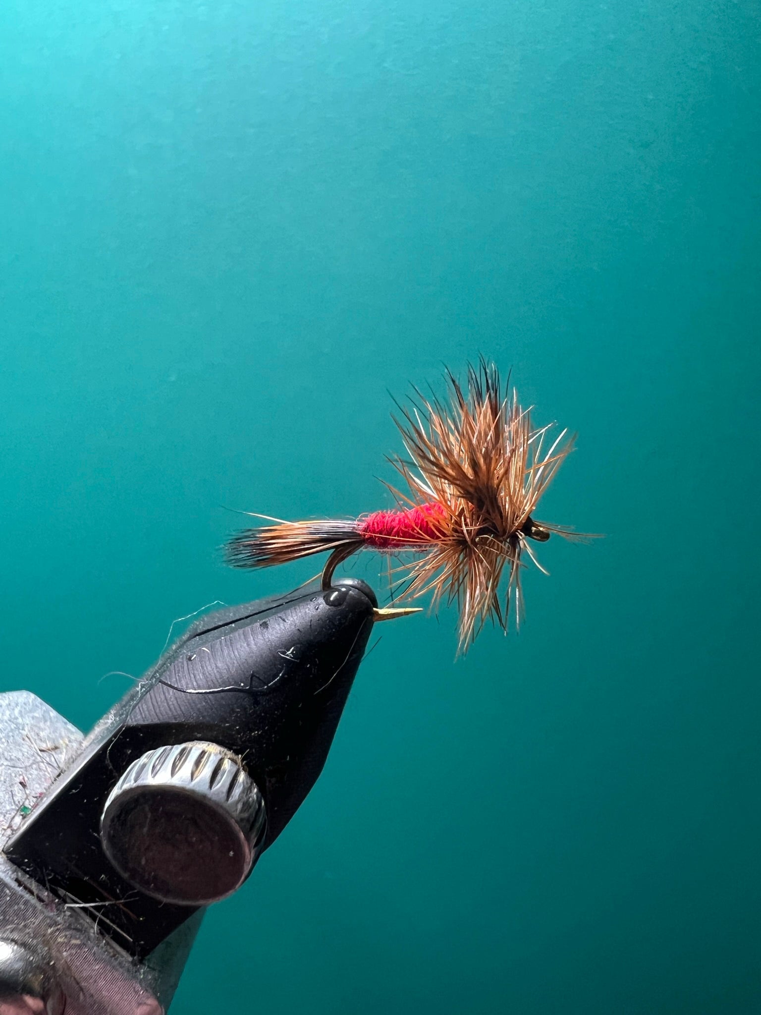 Wulff fly fishing lure with pink-and-tan fibers on a black hook